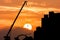 Excavator and crane working sunset background