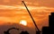 Excavator and crane working sunset background