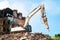 An excavator demolishes a brick house. Renovation concept of old dilapidated housing