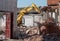 An excavator demolishes an industrial site for urban redevelopment in residential use