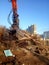 Excavator and destroyed building, earthquake, pile of rubble and debris, landfill