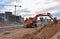 Excavator dig trench at a construction site. Trench for laying sewer pipes. Sewage drainage system for multi-story building.