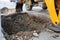 Excavator digging a deep trench in the city street