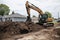 excavator digging into pile of dirt and rocks