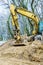 Excavator digging on site in forest environment.