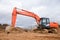 Excavator digs dirt during roadwork at construction site. Heavy machinery and earth-moving equipment