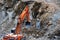 The excavator digs a pit for the disposal of old, concrete structures. Land clearing for the construction of residential buildings