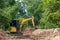 The excavator digs a soil. Digger loading trucks with soil. Excavator working on earthmoving at open pit mining. Excavator working