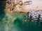 An excavator diligently constructs a dock or breakwater in the sea, its mighty arm reaching out from the shore, creating