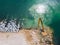 An excavator diligently constructs a dock or breakwater in the sea, its mighty arm reaching out from the shore, creating