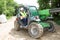 Excavator driver man operator with metal tracks unloading soil at construction