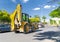 The excavator drives or goes fast on the street with heavy traffic with blue sky and green trees in background, Ankara, Turkey