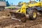 Excavator, dumper truck and bulldozer working on ground at construction site