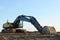 Excavator on earthworks at construction site. Backhoe on foundation work and road construction. Paving out sewer line. Heavy