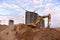 Excavator on earthworks at construction site. Backhoe on road work and laying sewer pipes. Construction machinery for dig ground,