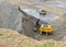 Excavator with electric shovel loading the rocks in mining truck at quarry. Haul truck transports minerals in the open pit.