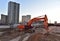 Excavator during excavation at construction site. Backhoe on road work. Heavy Construction Equipment Machines for Earthworks.