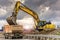 Excavator filling a truck with earth for the construction of a slope for the construction of a road