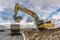 Excavator filling a truck with earth for the construction of a slope for the construction of a road