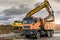 Excavator filling a truck with earth for the construction of a slope for the construction of a road