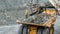 Excavator fills dump truck. Bucket excavator closeup loads stones into body of dump truck on mining or construction of