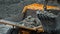 Excavator fills dump truck. Bucket excavator closeup loads stones into body of dump truck on mining or construction of