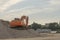 Excavator on gravel near the riverside in the blue sky