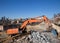 Excavator with an industrial hydraulic hammer performs the work of dismantling reinforced concrete structures