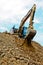 Excavator on large pile of dirt