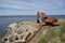 The excavator levels the sandy bank of the Volga River. Ulyanovsk. Russia