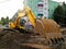 An excavator levels the soil at a construction site.