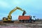 Excavator load the sand to the heavy dump truck on construction site.