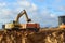 Excavator load the sand to the heavy dump truck on construction site. Excavators and dozers digs the ground for the foundation