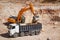 Excavator loading dumper truck with sand