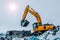 Excavator is loading excavation to the truck. Excavators are heavy construction equipment consisting of a boom, dipper or stick