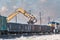 Excavator loading old railroad ties in open boxcars