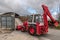 Excavator loading salt for road treatment in winter