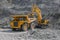 Excavator loads ore into a large mining dump truck