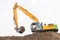 Excavator makes noise barrier with sandy soil