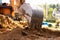 An excavator metal bucket digs sand or clay on a construction site while digging a trench