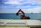 Excavator on metal roof top on sea water with yachts on the horizon