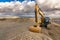 Excavator moving dirt and sand at a construction site