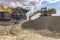 Excavator moving stone and rock for gravel transformation