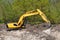 Excavator near heaps of sand and soil at construction site