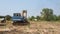 An excavator operates on an agricultural land