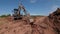 Excavator operates digging trench at open construction site