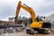 An excavator among a pile of garbage after dismantling an illegally constructed building