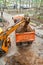 Excavator pours dirt into bodywork of tipper truck in yard