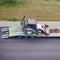 An excavator pulls into a truck trailer for transportation to another location