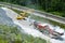 Excavator and rock grinder working to produce fine ground pebbles from large rocks next to railroad tracks